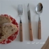 Một Bao-Han Feng in cùng một con dao gỗ và nĩa đặt một bộ đồ ăn bằng thép không gỉ Bộ đồ ăn phương Tây - Đồ ăn tối