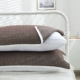 Пара темно -коричневых полотенец с чистыми подушками