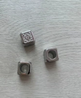 Одна серебряная квадратная бусина.